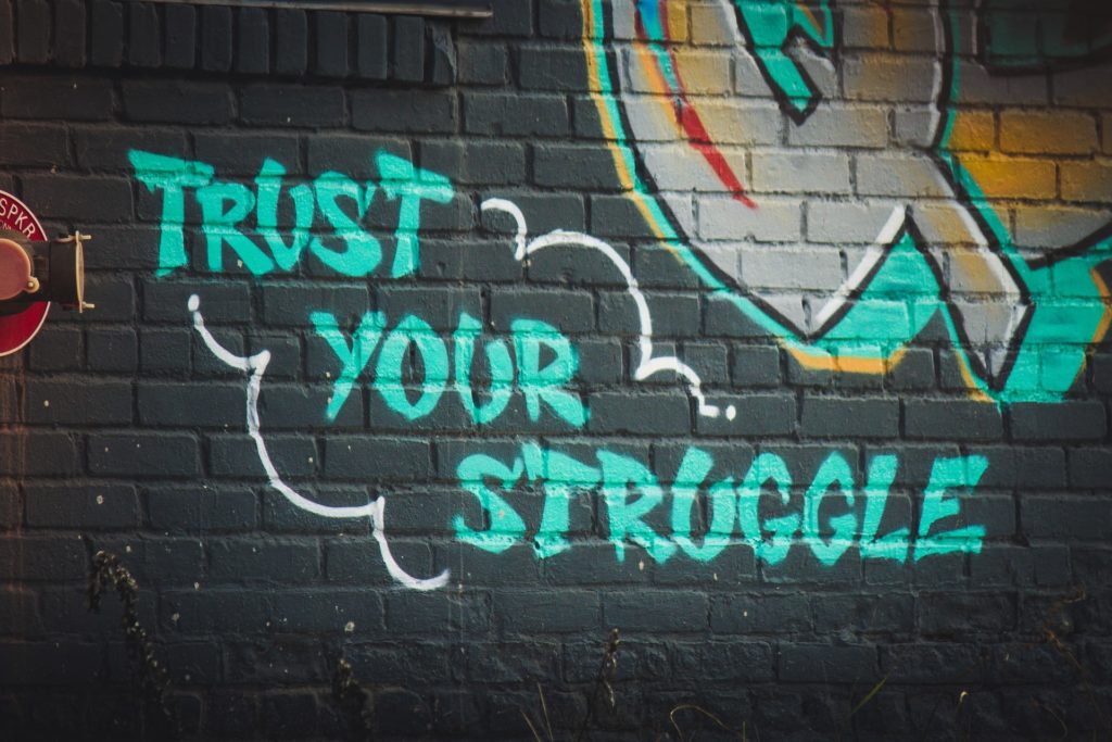 Graffiti of the words "trust your struggle"